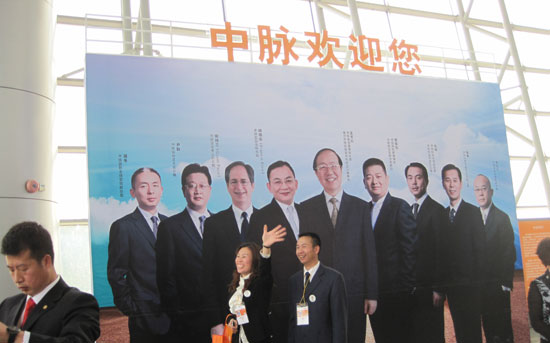 时间进入下午12：30分，越来越多的经销商进入会场展厅，此次年会中脉推出丰富多彩的产品展台，有专门制作的周年回顾展览墙，让到会的中外经销商都能了解到中脉公司一年来艰苦奋斗的事业足迹，增加跟随中脉的信心；有中脉领导人形象展示，亲切的面容，引得经销商不停驻足合照；有巴马生态养生展板，绿意盎然的展板给大家清新的感觉，仿佛巴马近在咫尺，增加对中脉生态产品的信任，并配了详细的产品说